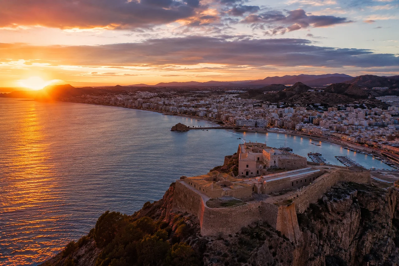 Vista de Águilas al atardecer con el Castillo de San Juan sobre la bahía, a 10 minutos de Calabardina